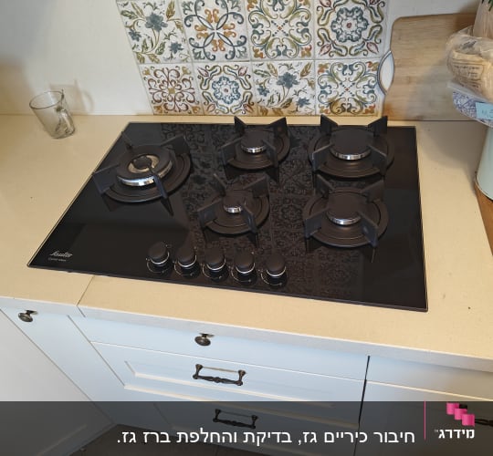 כיריים גז שחורות עם חמישה מבערים וכפתורי שליטה